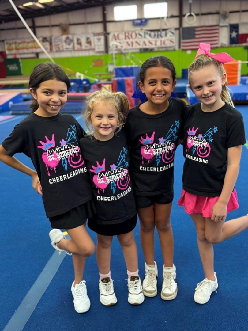 Four young cheerleaders smiling – Houston competitive cheer program.