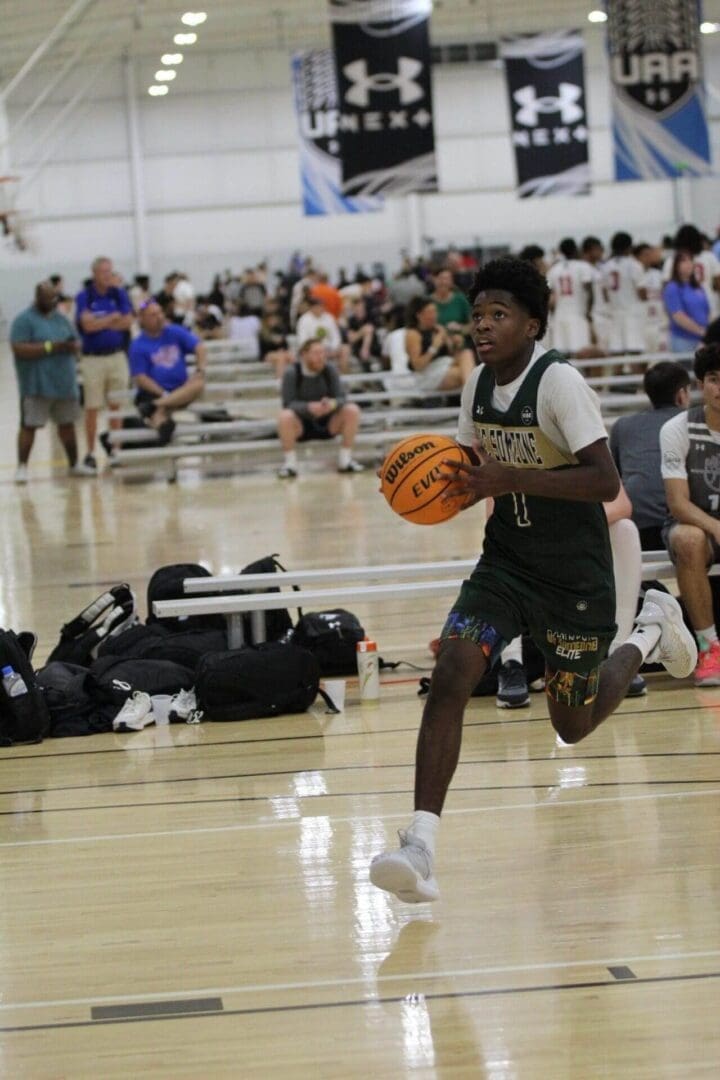 Basketball player dribbling on indoor court.