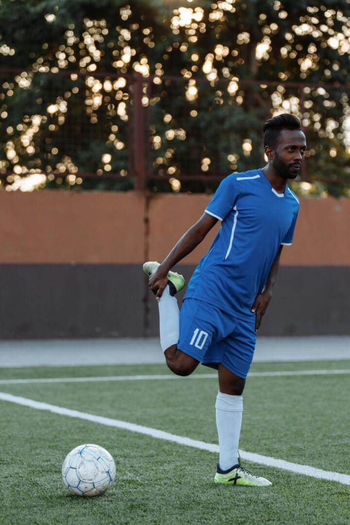 Soccer player stretching on the field as part of active recovery