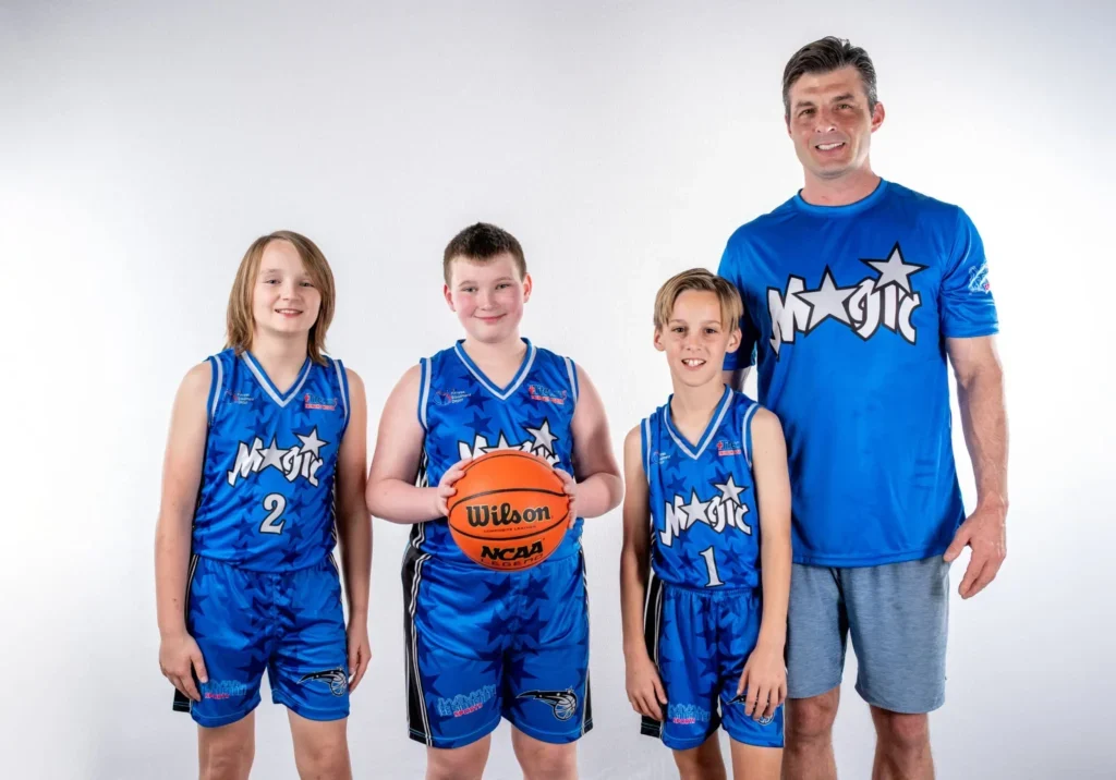 Basketball coach and team posing together.