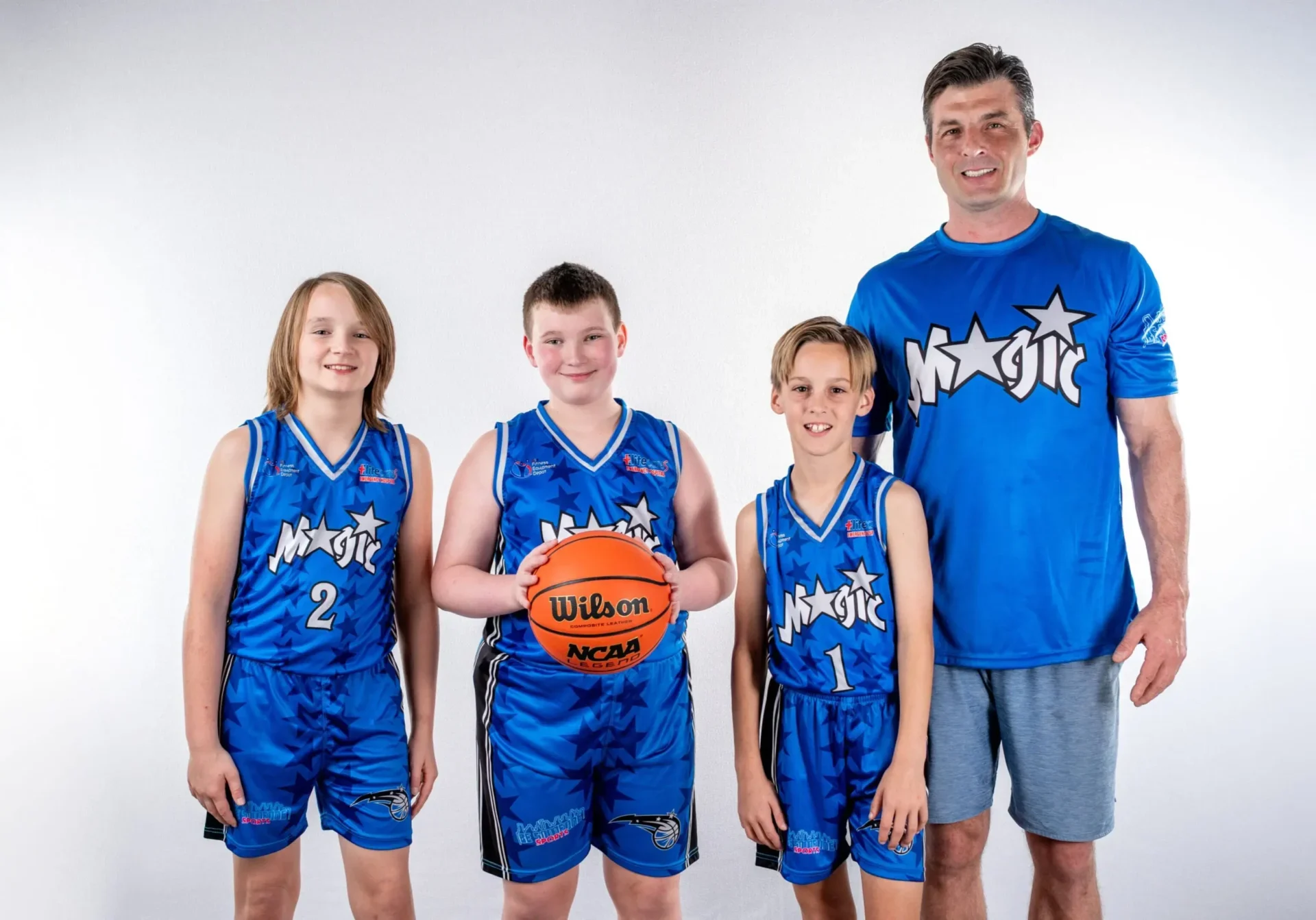 Basketball coach and team posing together.